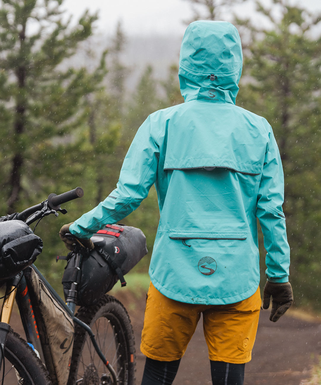 Cyclist wearing an outdoor waterproof jacket from the Porlite &times; Showers Pass collaboration